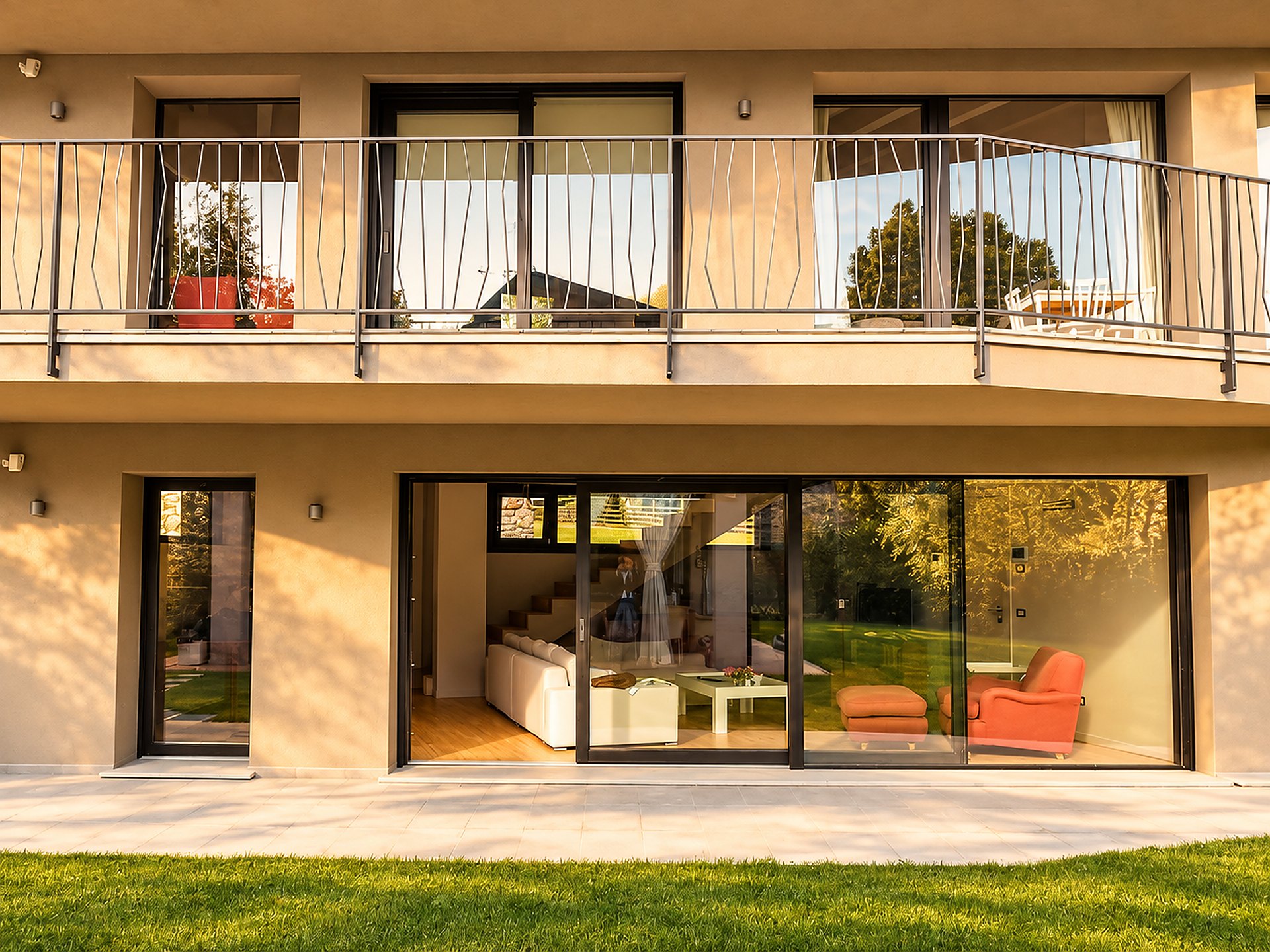 Casa moderna con ampia vetrata scorrevole in legno e alluminio che affaccia sul soggiorno